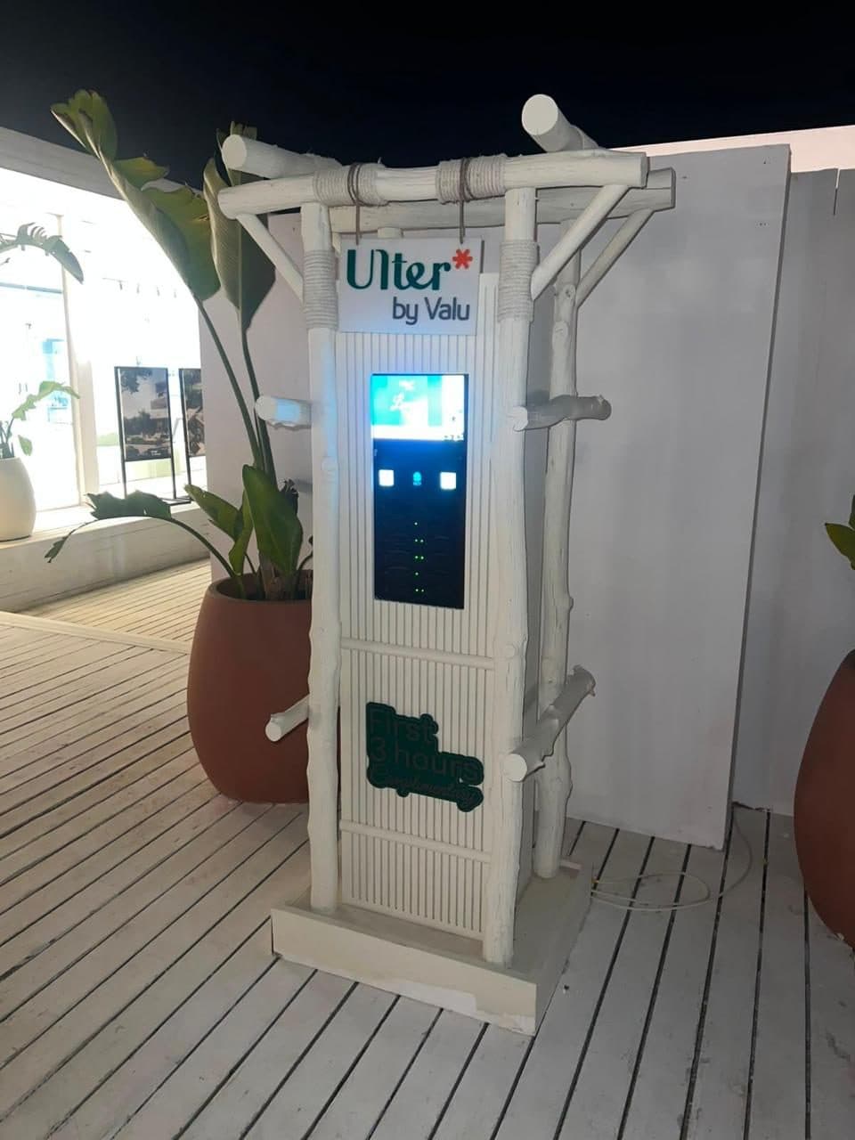 A pale driftwood-framed charging station on a white deck, carrying Ulter by VALU branding